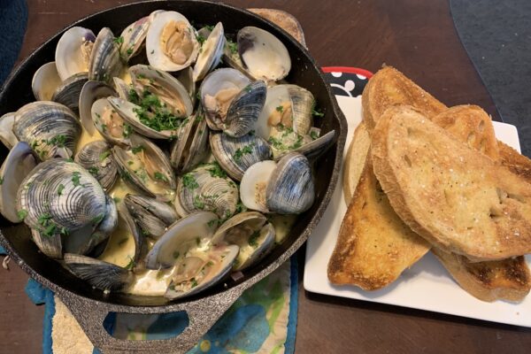 Littleneck clams in lemon-white butter sauce in cast iron pan by Chef Wendell White