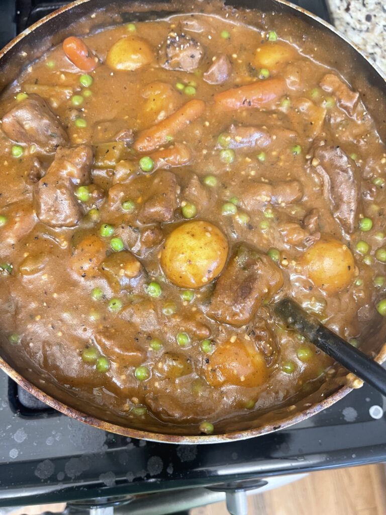 One-pot beef stew with potatoes, carrots, celery, onion, and peas simmered until tender