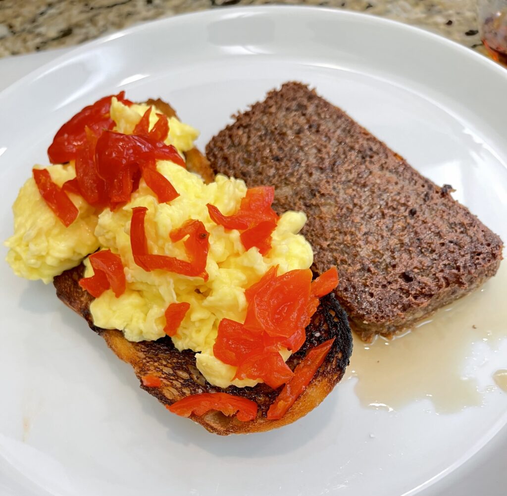 Scrambled eggs on toast topped with papaws, served with pan fried scrapple