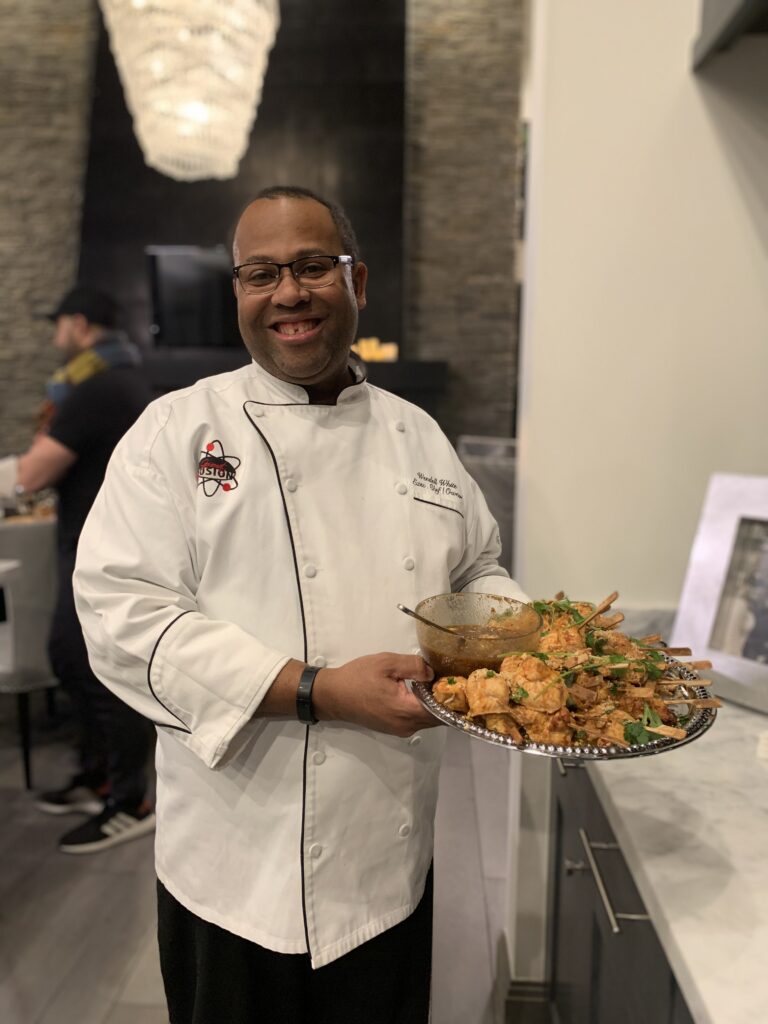 Chef Wendell White presenting a platter of appetizers while catering a private event in Utah.
