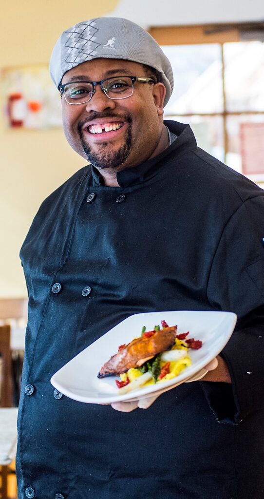 Chef Wendell White holding a finished plate for his guide on how to season food properly