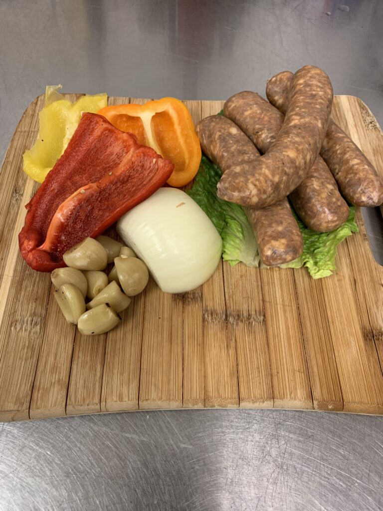 Chef Wendell White demonstrates prep-ahead cooking ingredients including sausage, onions, peppers, and garlic for fast weeknight meals.