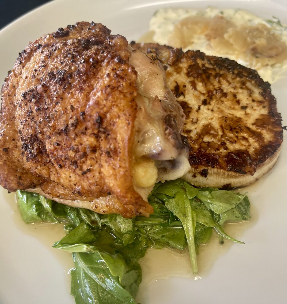 Pan-seared chicken thigh with braised arugula, fondant turnips, and lemon-basil aioli.